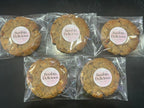 12 Goji White Chocolate Lactation Cookies. Five cookies in clear packaging with 'Boobin delicious' labels on a dark background
